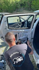 Technicien amlauto réparant une portière de voiture à Cadalen en extérieur, service à domicile,